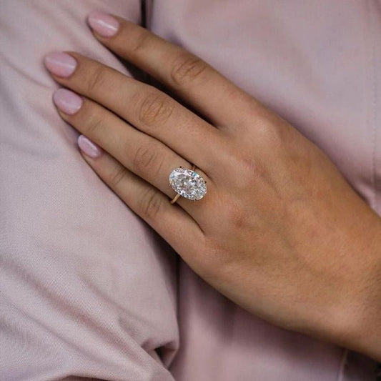 An oval-shaped cubic zirconia ring on a person's finger, with the ring's prominent stone clearly visible.